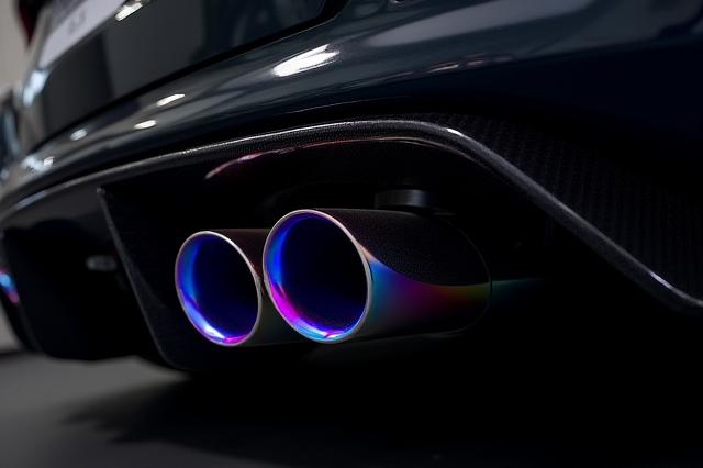 Terminali di scarico in titanio con colorazione iridescente dovuta al calore, montati su un'auto sportiva.